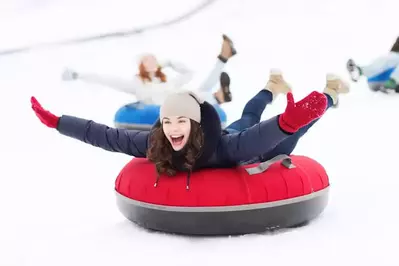 girl snow tubing in the mountains