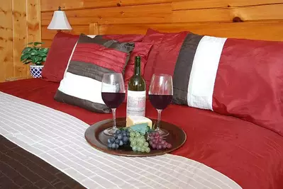 Wine and grapes on the bed of Eagles Perch, one of our Pigeon Forge mountain cabins.