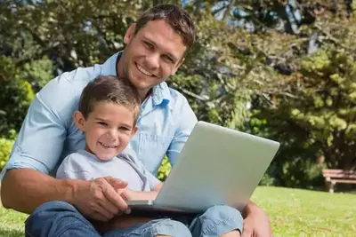Dad and son using laptop