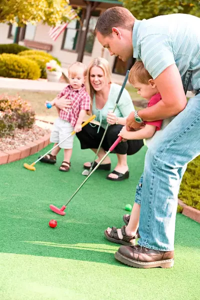 family playing mini golf