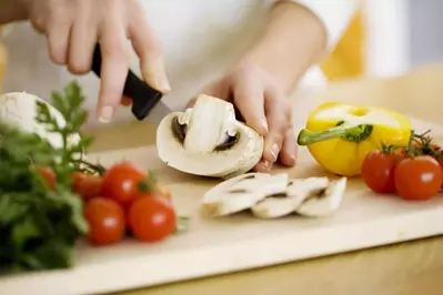 woman chopping food on cutting board