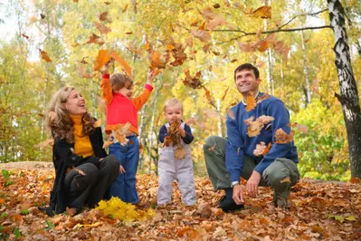 Family playing in the leaves
