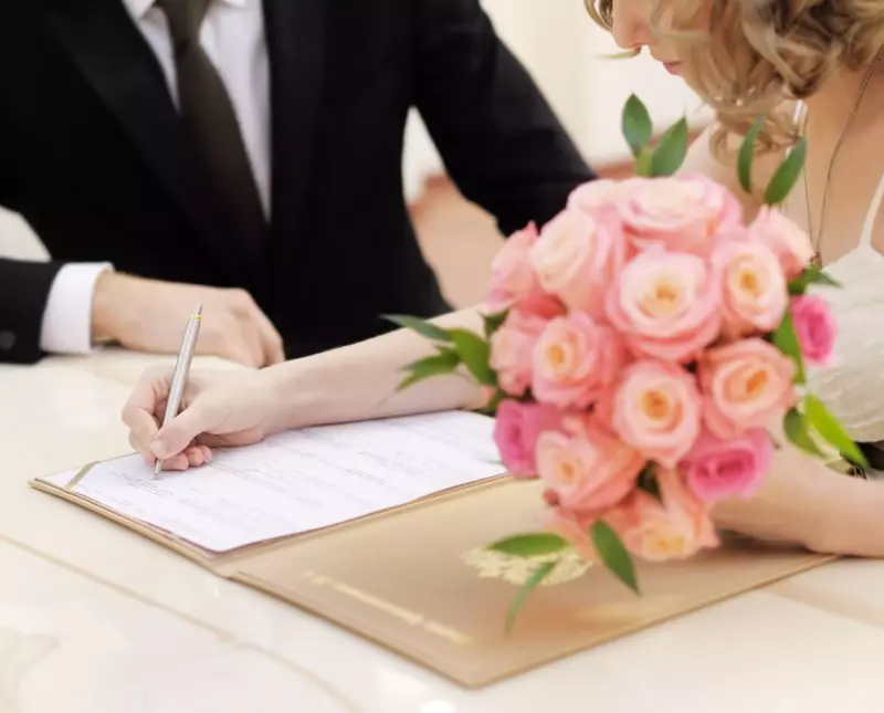 bride and groom signing marriage license