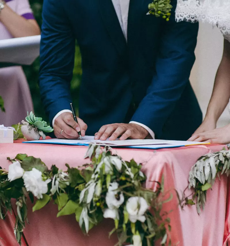 groom and bride signing marriage license