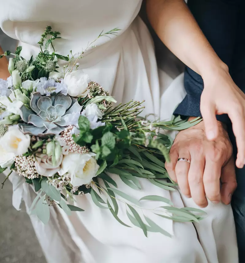 close up of bride and groom holding hands