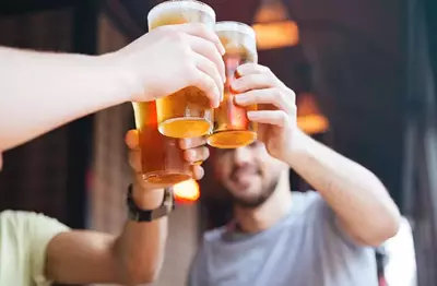 Three men clinking beer glasses