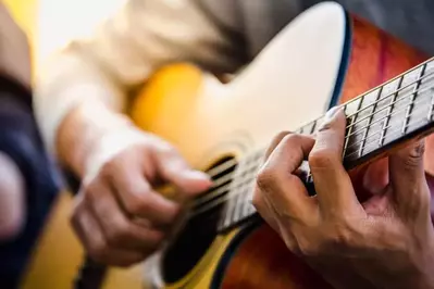 closeup of hands playing a guitar