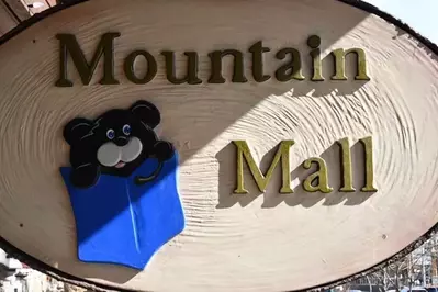 small sign for the mountain mall with bear on it. 