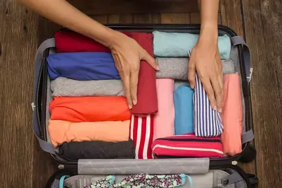 person packing their suitcase for a vacation