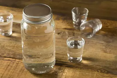 moonshine in a jar and shot glasses