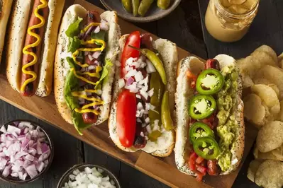 four hot dogs with all kinds of toppings