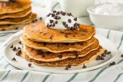 stack of pancakes with whipped cream and chocolate chips