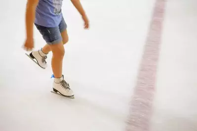 girl in short sleeves and shorts ice skating