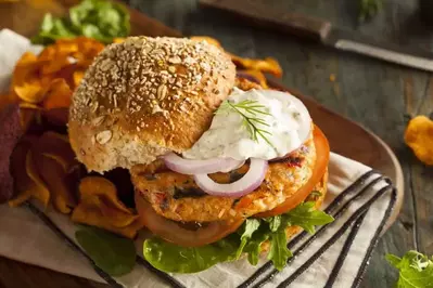 A mouthwatering salmon burger with tartar sauce.