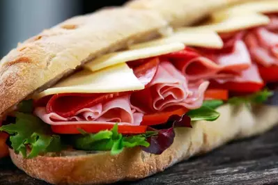 A delicious submarine sandwich with meats, cheese, lettuce, and tomato.