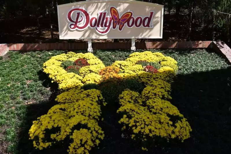 A sign and butterfly flower arrangement at the entrance to Dollywood.