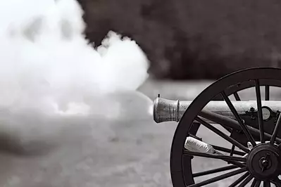Black and white photo of a cannon being fired.