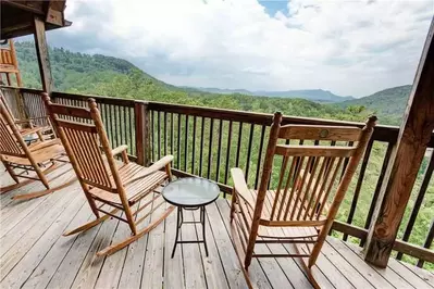 Chairs on the deck of a luxury Gatlinburg cabin with mountain views.