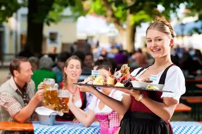 A waitress with a tray of food at an Oktoberfest celebration.