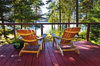 Two chairs on the porch looking into the forest