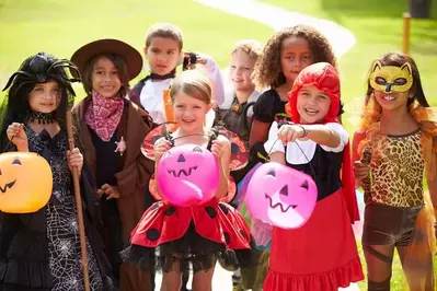 Kids in their Halloween costumes ready to trick or treat.