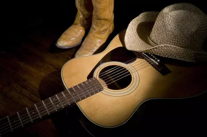 Country music guitar, hat, and boots.