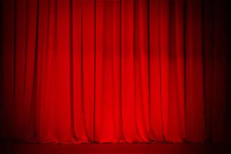 Red curtain on stage at a theater.