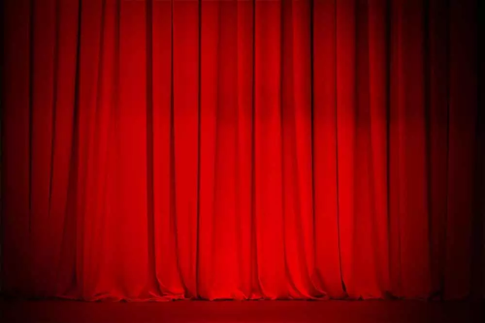 Red curtain on stage at a theater.