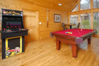 The awesome game room with a pool table and arcade games at a Pigeon Forge cabin.
