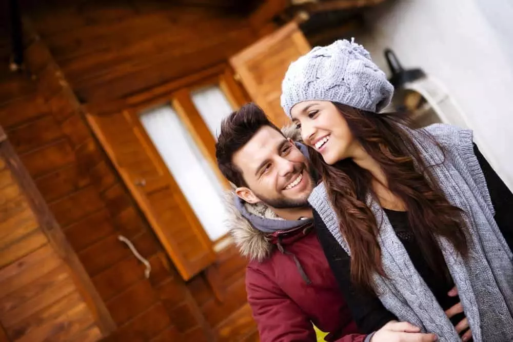 Couple holding each other smiling at their honeymoon cabin in Gatlinburg