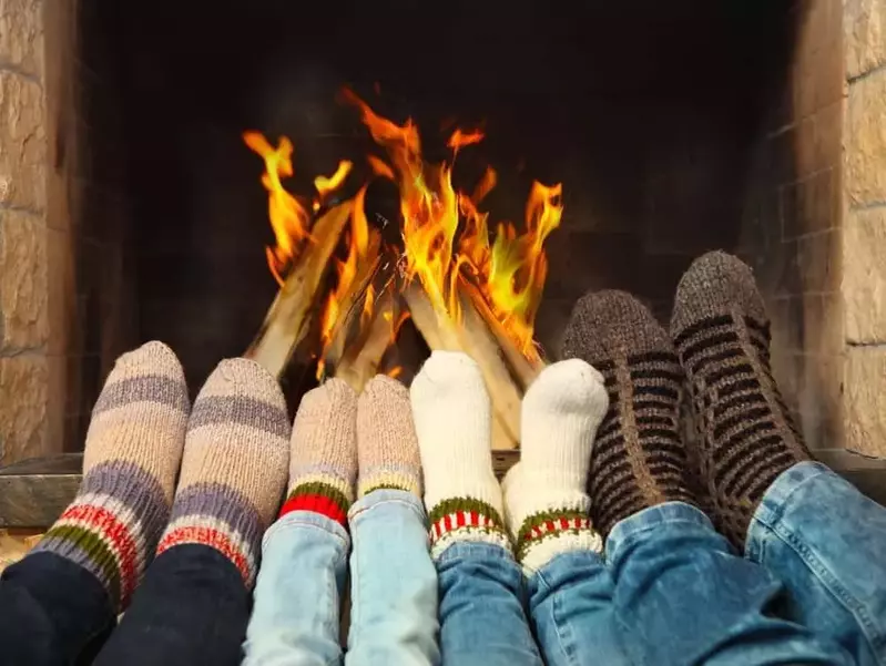 Family of four warming up feet in front a fireplace in a Pigeon Forge group cabin
