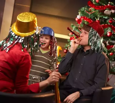 Family celebrating New Year's Eve with silly hats