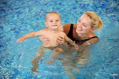 Mother playing with baby in indoor pool