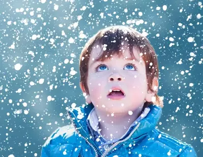 Little boy watching the snow fall