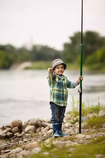 Little boy showing off the fish he caught