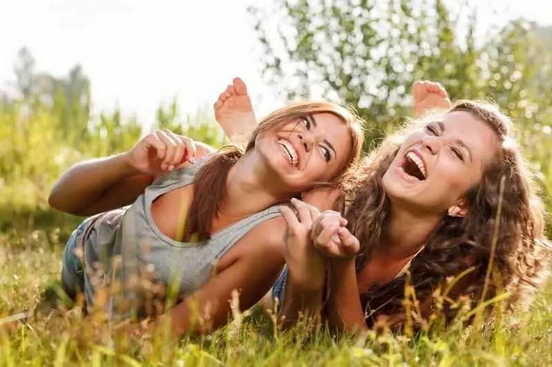 friends laughing together in grass
