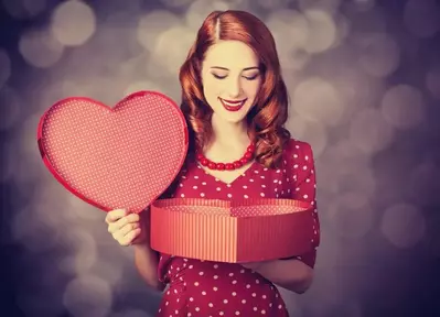 Woman opening heart shaped box for Valentine's Day