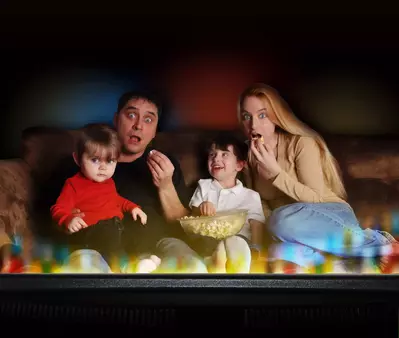 Family watching a movie while eating popcorn