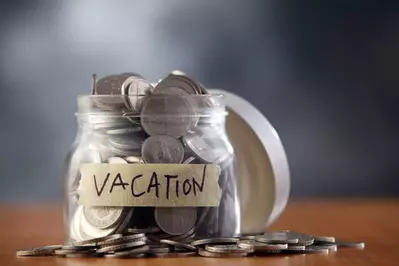 Jar filled with coins labeled "Vacation"