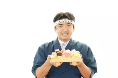 Sushi chef holding a plate of sushi
