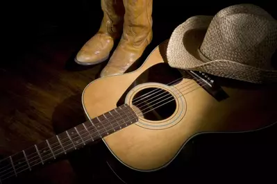 Country music guitar, cowboy hats, and boots