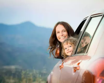 family in car with mountain background