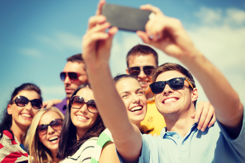 Group of smiling people taking a selfie