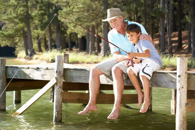 Grandfather and grandson fishing from a dock