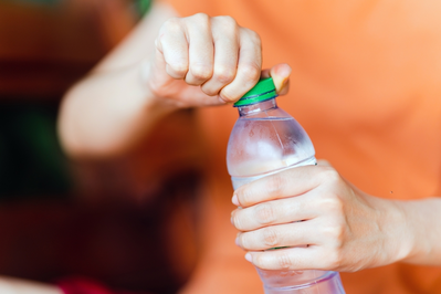 unscrewing cap on plastic water bottle