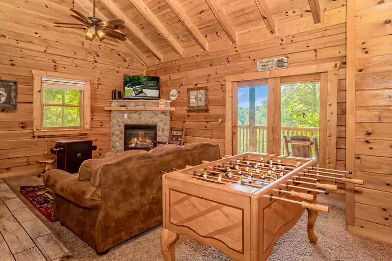 Naughty By Nature living room with fireplace, arcade games, and foosball table